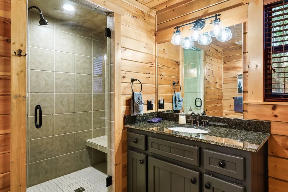 A modern and inviting bathroom with a spacious shower area, a stylish vanity with dual sinks, ample mirrors, and soft accent lighting. The clean lines and soothing color palette evoke a spa-like feel.